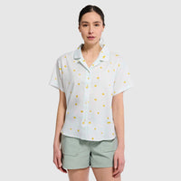 Light blue short-sleeve camp shirt with yellow polka dot pattern, worn by woman