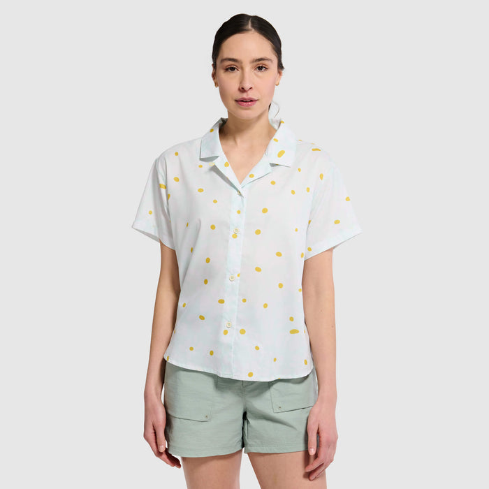 Light blue short-sleeve camp shirt with yellow polka dot pattern, worn by woman