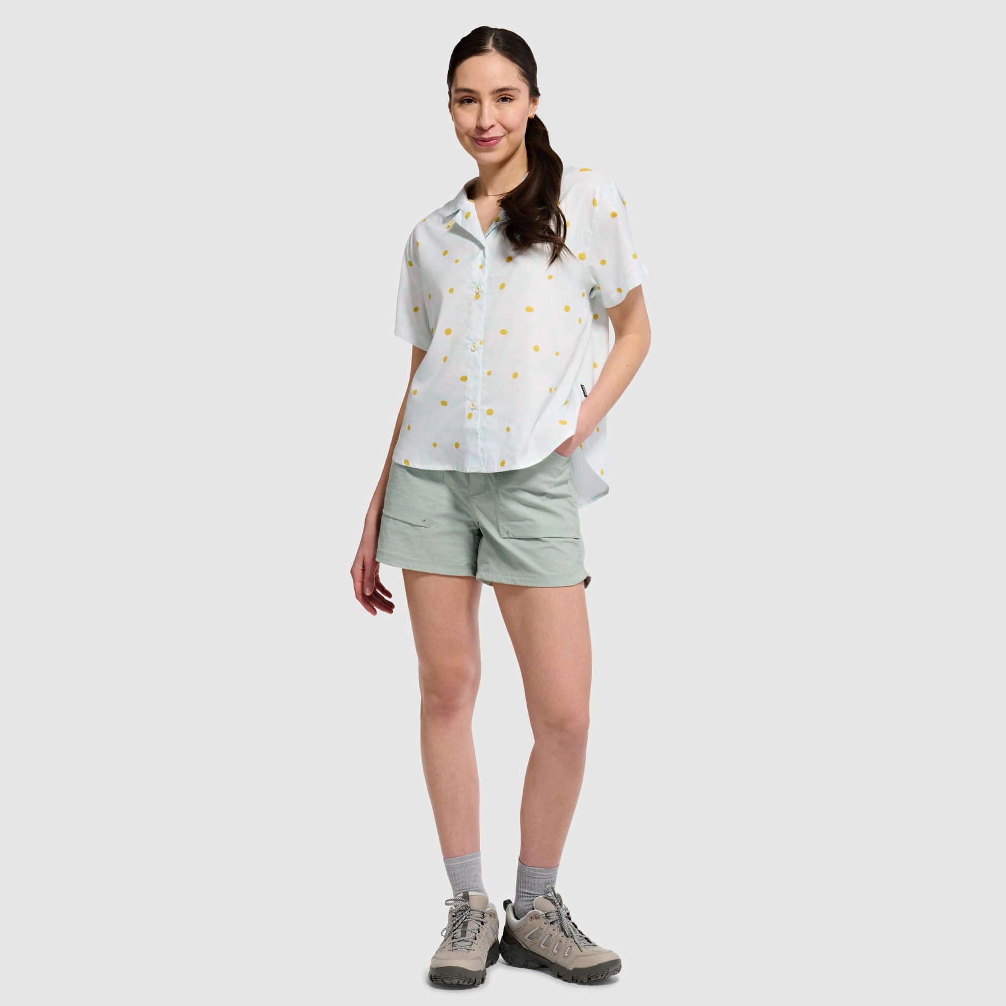 White short-sleeve camp shirt with yellow polka dots worn with light green shorts