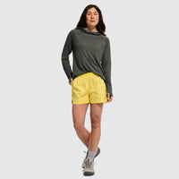 Woman wearing yellow athletic shorts with elastic waistband, full body view on neutral background