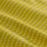 Yellow-green athletic shorts with geometric triangle pattern, draped fabric detail view