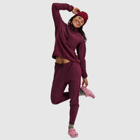 Woman wearing burgundy fleece jogger pants in matching coordinated set, styled with pink footwear