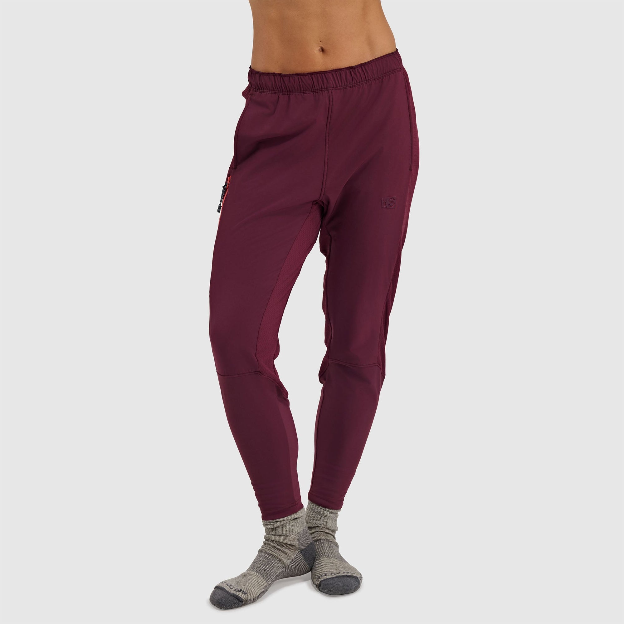 Women's burgundy fleece pants with elastic waistband and cuffs, worn with gray socks
