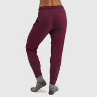 Burgundy fleece pants with textured panel details shown from behind on model
