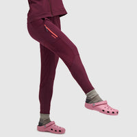 Deep red fleece leggings with side pockets and orange zipper details, side view