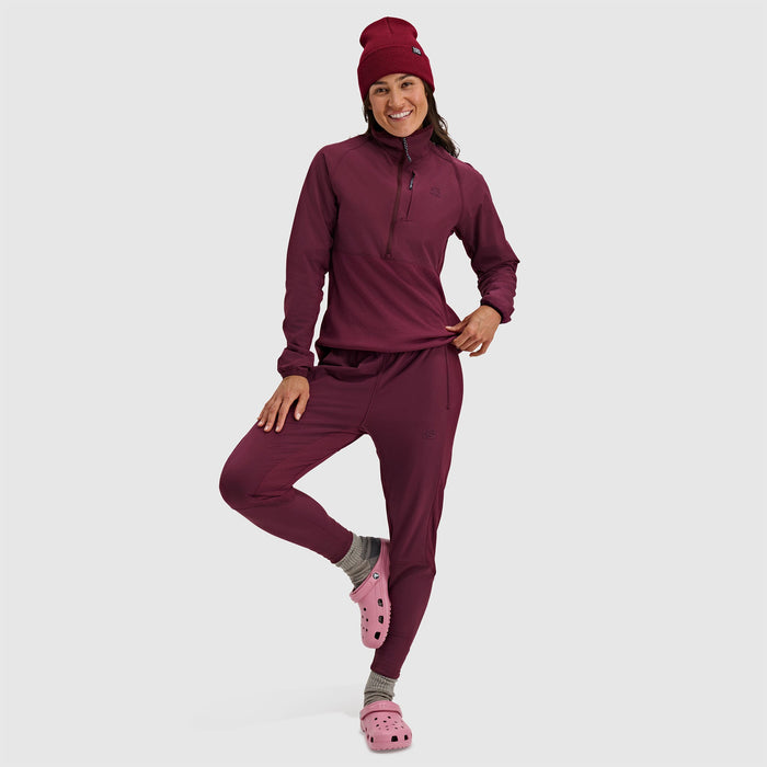 Woman wearing burgundy fleece half-zip pullover and matching pants with beanie