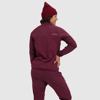 Woman wearing deep burgundy half-zip fleece pullover and matching beanie, shown from back view