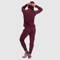 Woman wearing burgundy fleece pullover jacket and matching leggings, back view with hood up