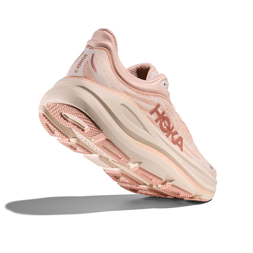 Light pink running shoe with mesh upper and thick cushioned sole, angled side view