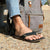 Black flip-flop sandals worn with jeans in outdoor lifestyle setting