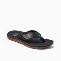 Black flip-flop sandal with textured footbed and brown rubber sole, side angle view