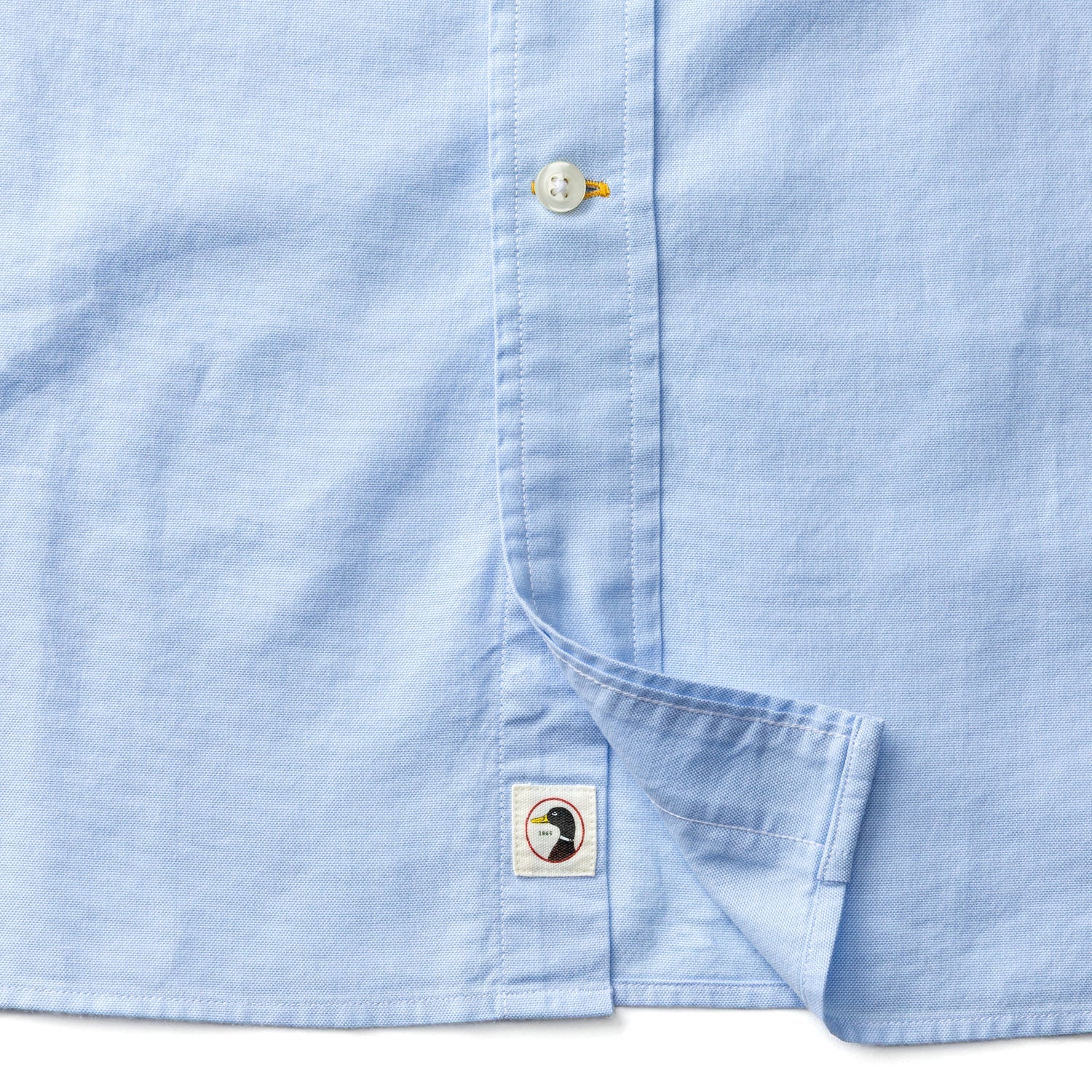 Light blue long sleeve cotton oxford shirt showing button placket and chest pocket detail