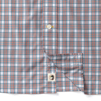 Close-up detail of plaid poplin shirt showing buttons, chest pocket, and duck logo patch