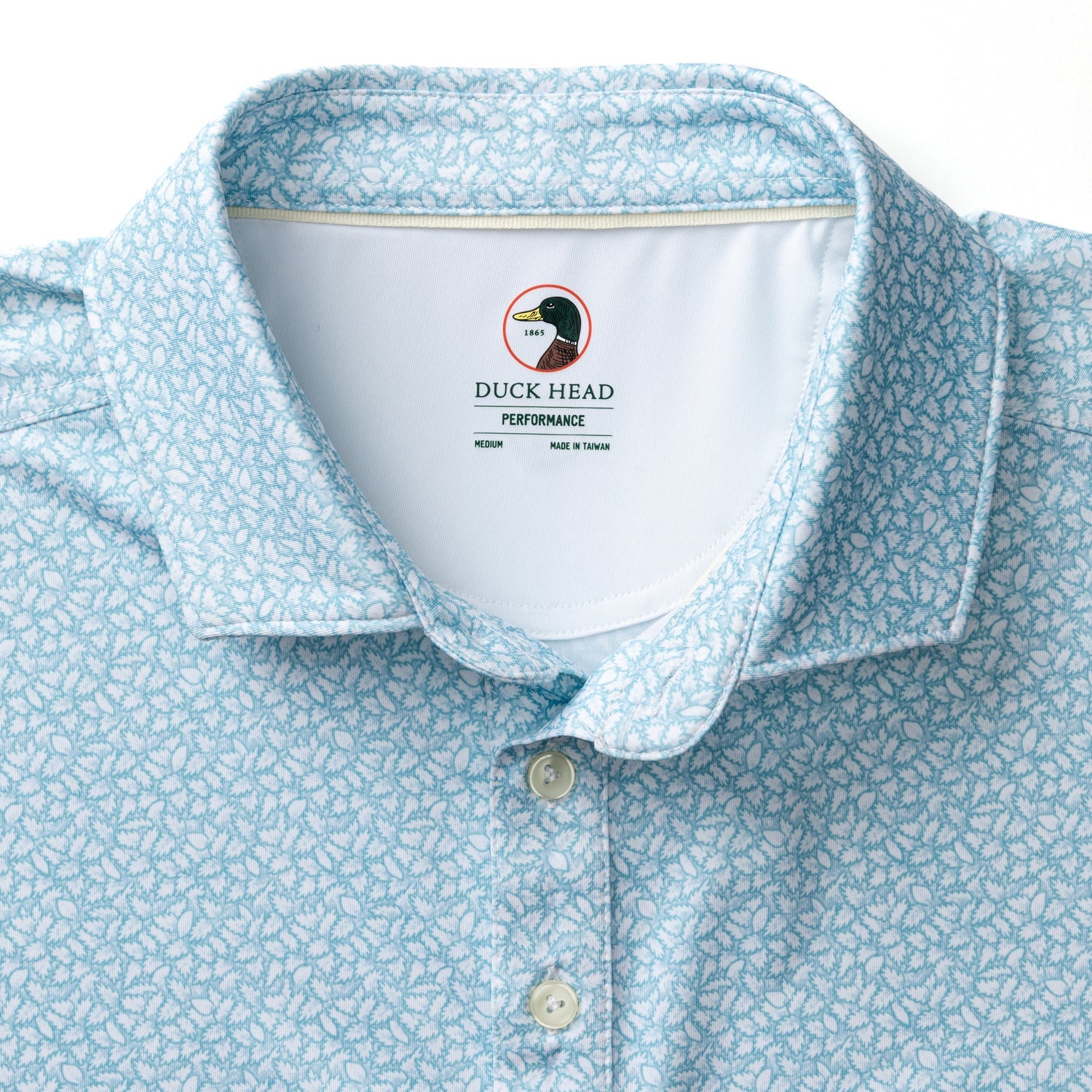 Light blue polo shirt with white floral print, collar and button placket detail view