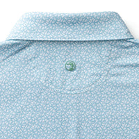 Light blue polo shirt with white floral pattern, showing collar and button detail