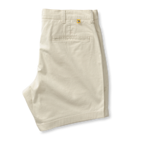 Light beige chino shorts with gold button detail and back pocket, folded flat view