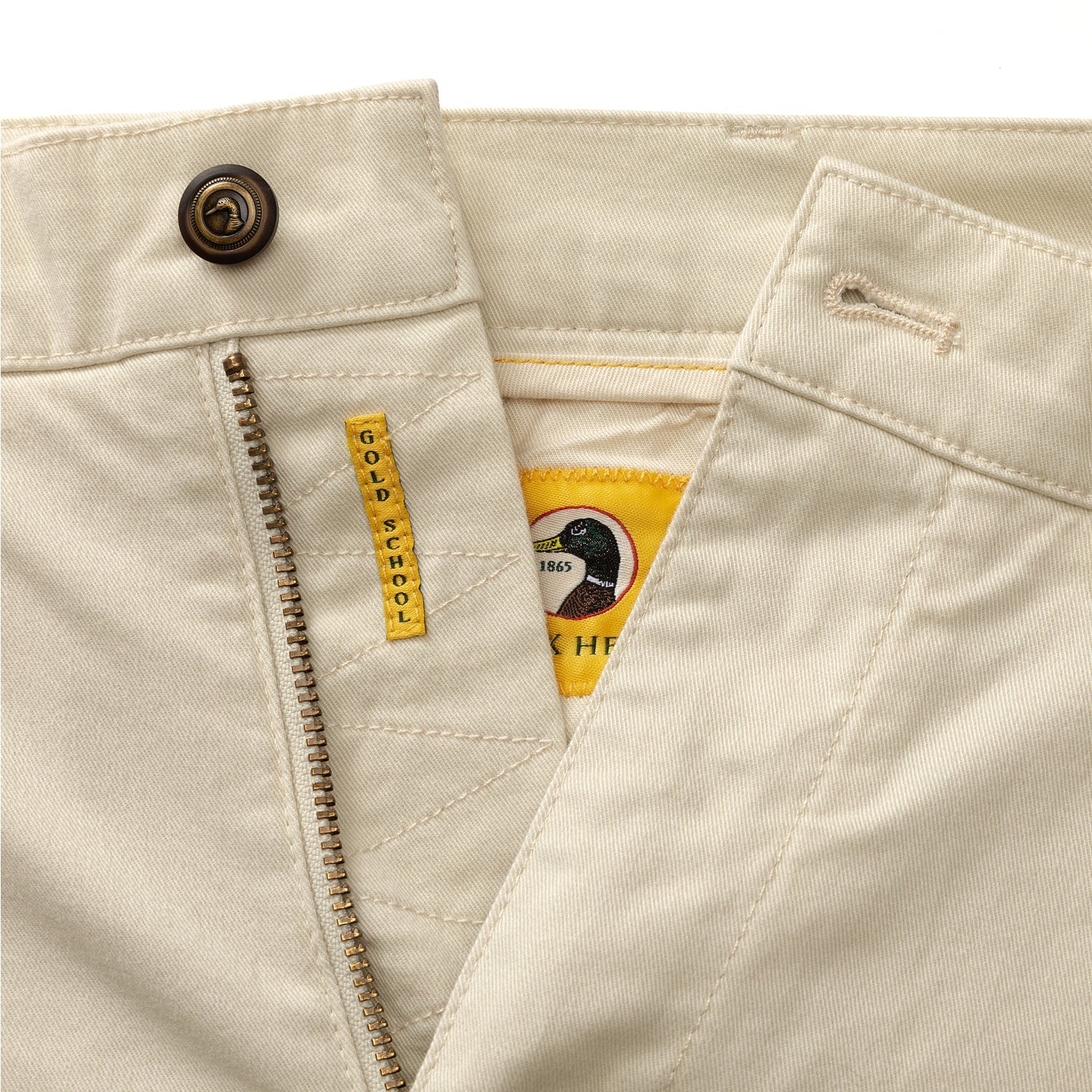 Light colored chino shorts with zipper fly and button closure, detail view showing waistband
