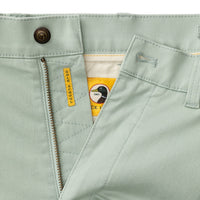Light green chino shorts with zipper fly and button closure, detail view of waistband