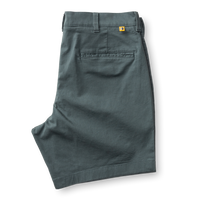 Men's chino shorts in sage green color, folded to show back waistband and pocket details