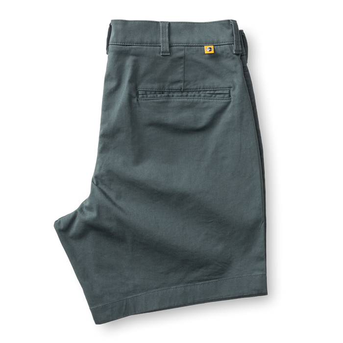 Men's chino shorts in sage green color, folded to show back waistband and pocket details