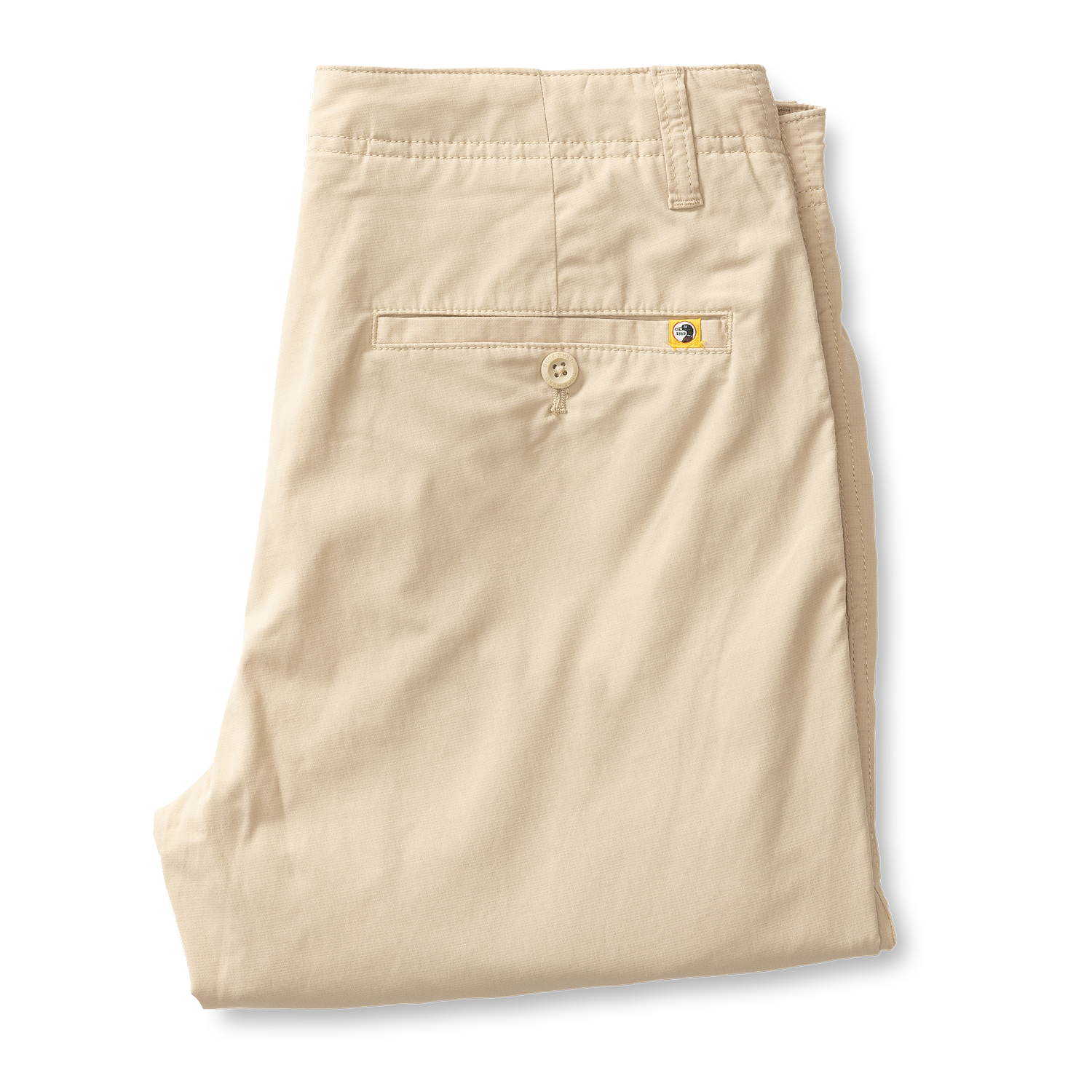 Beige chino pants folded showing back pocket with button detail and brand tab