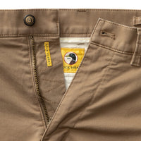 Close-up detail of chino waistband, zipper fly, and interior brand label with duck logo
