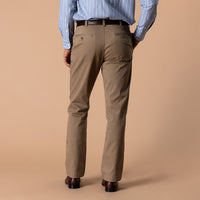 Men's classic fit chino pants in tan, back view, with belt and leather shoes