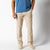 Light beige chino pants on male model with blue shirt, front view studio photo