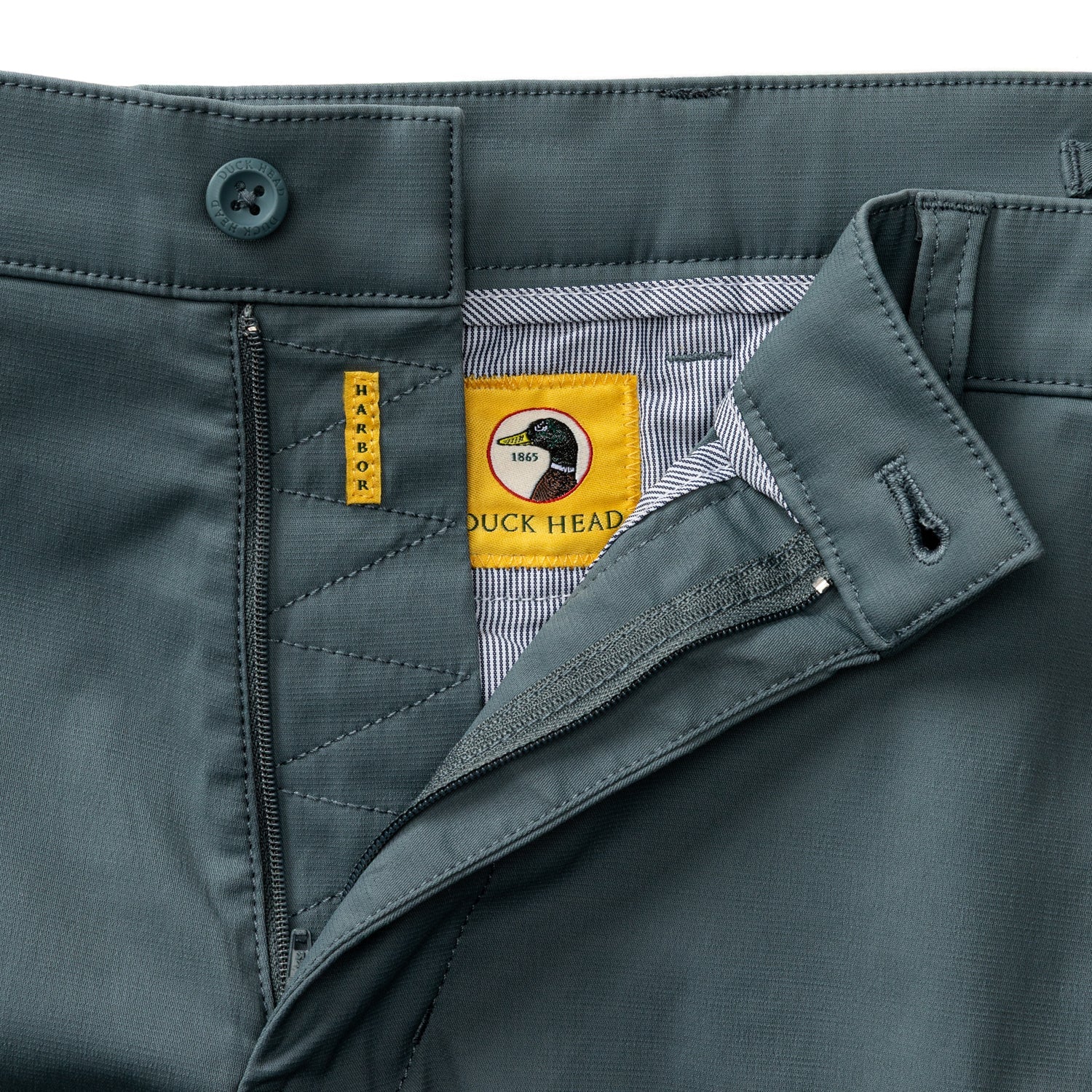 Men's chino pants waistband and fly detail showing button closure and brand label
