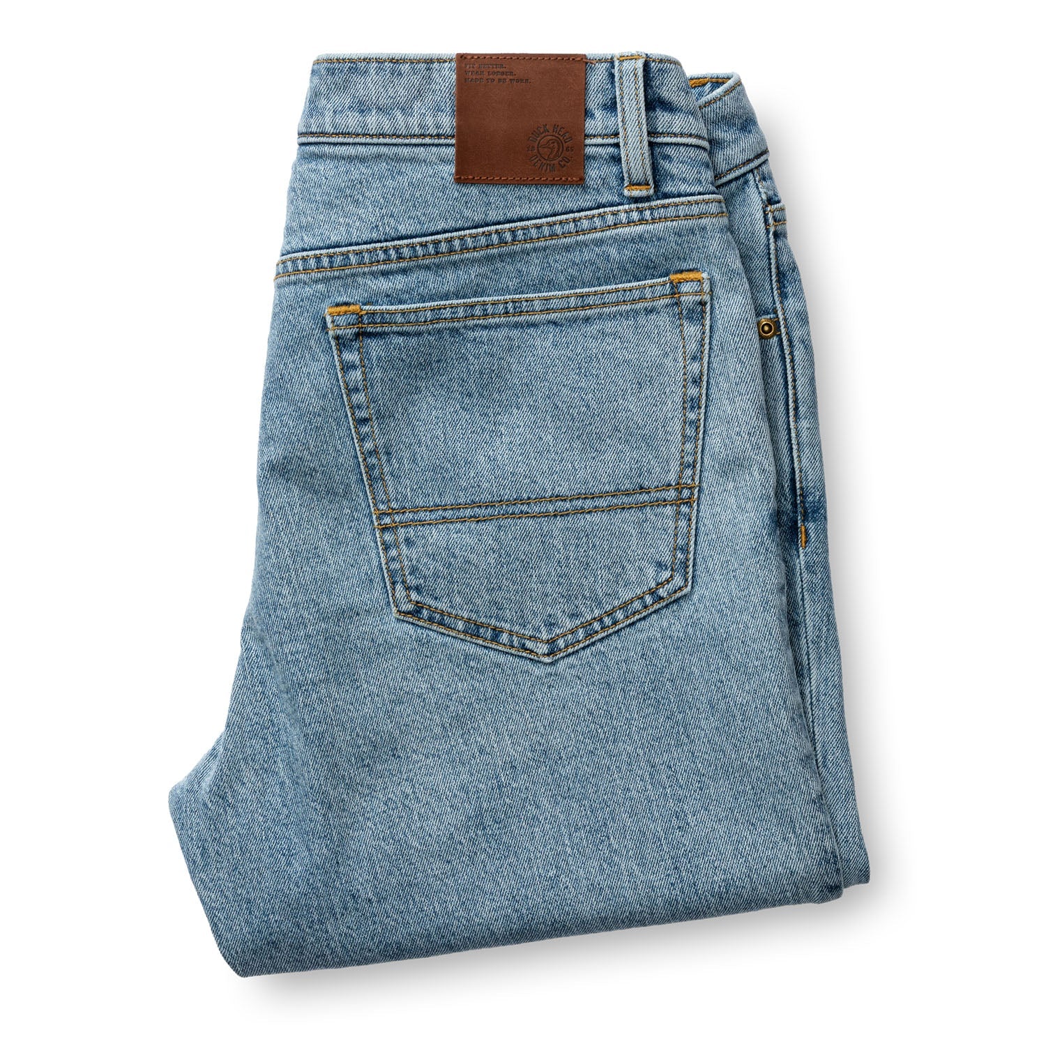 Folded light blue denim jeans showing back pocket and brown leather waistband label