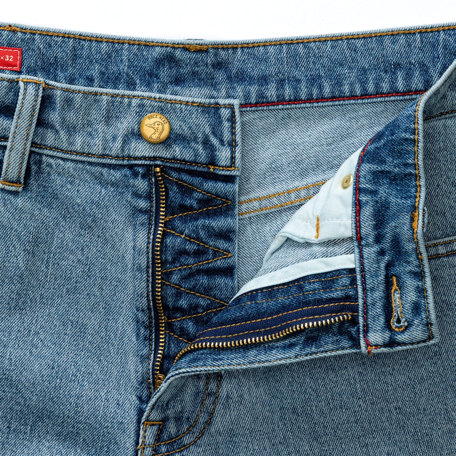 Close-up of light blue denim jeans showing waistband, button closure, and front zipper detail