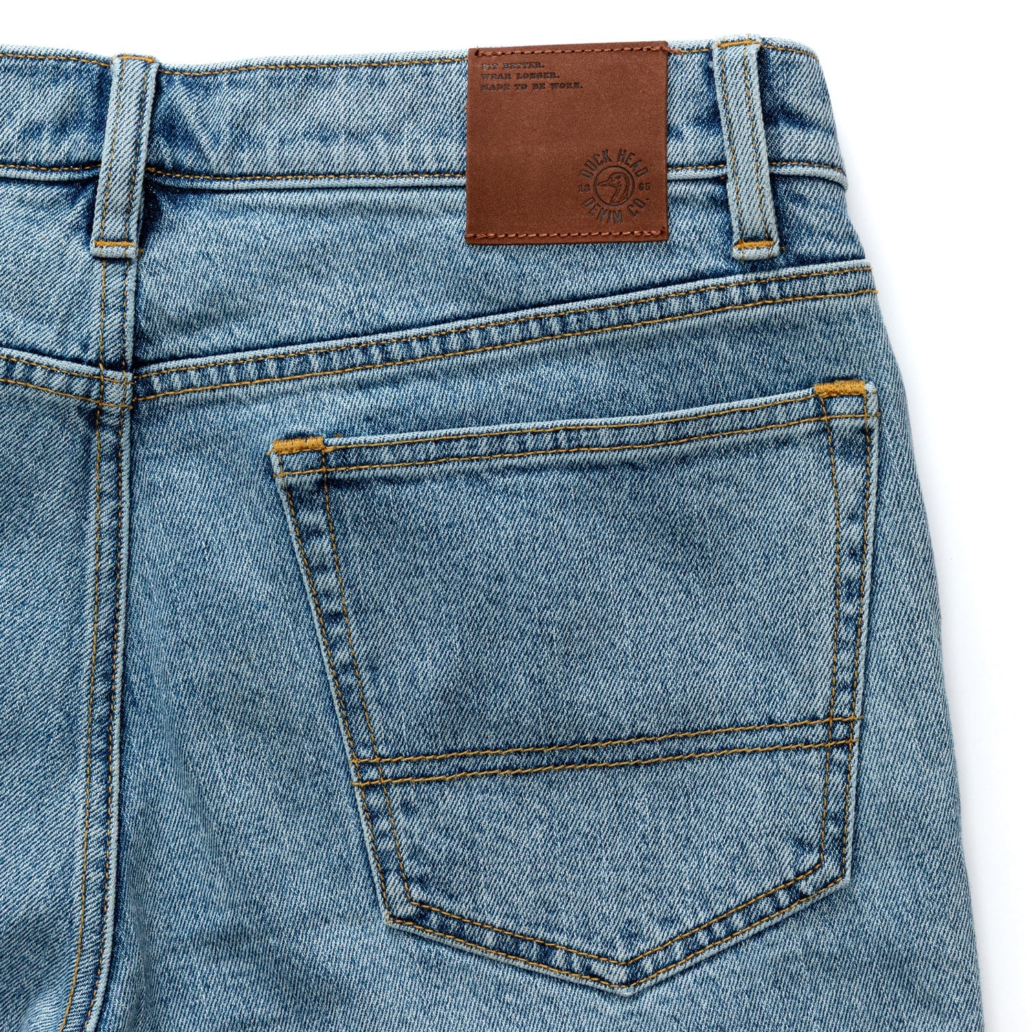 Light blue denim jeans back view showing pockets and brown leather waistband label