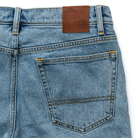 Light blue denim jeans back view showing pockets and brown leather waistband label
