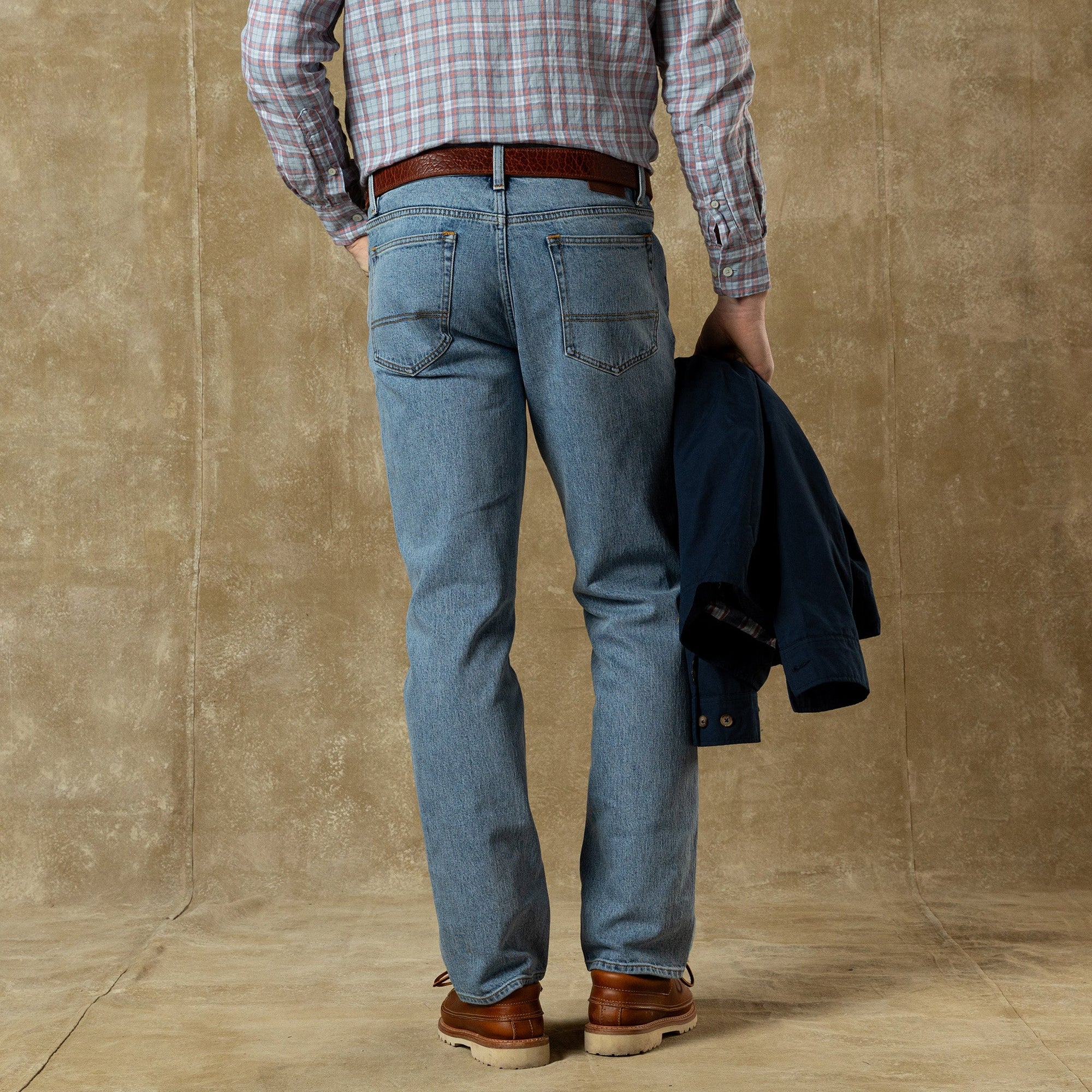 Men's straight fit jeans in light blue denim, rear view showing back pockets and styling