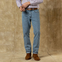 Men's straight fit light wash denim jeans with brown leather belt and suede boots