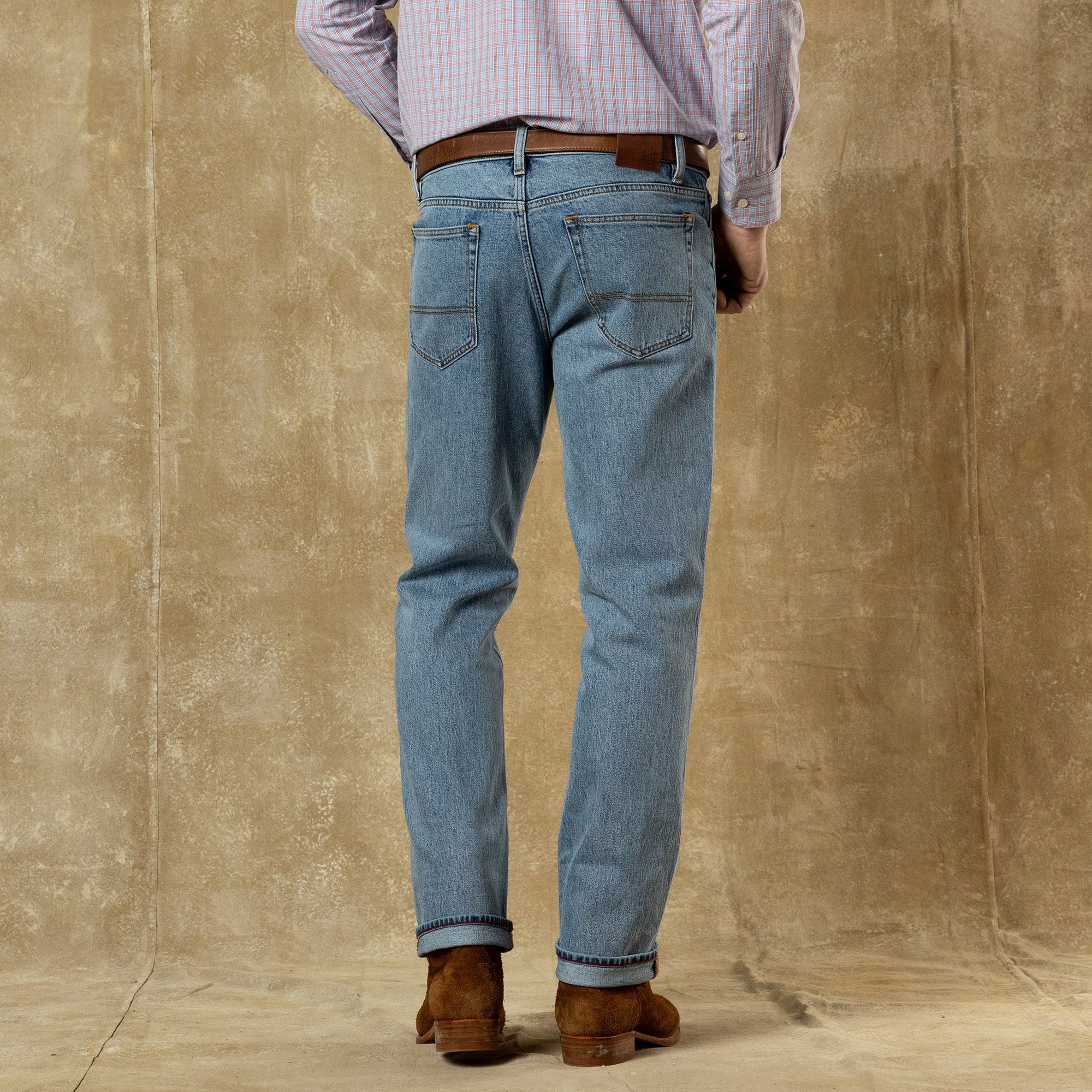 Light blue denim jeans with straight fit shown from back view with cuffed hem