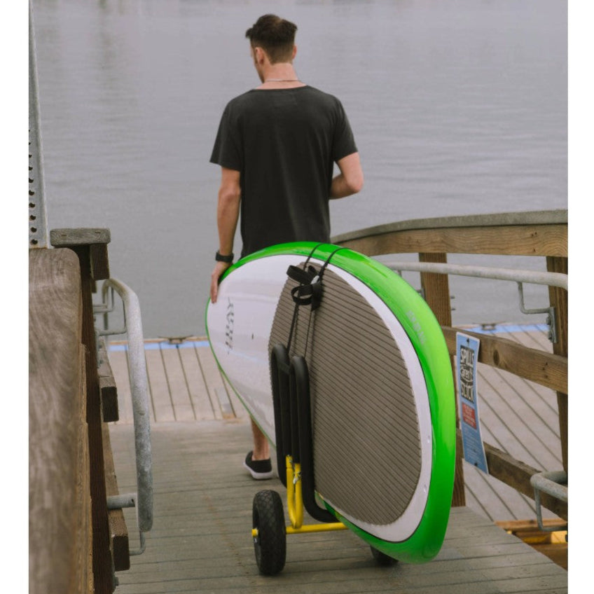 Wheeled cart holding paddleboard on wooden dock with person walking away