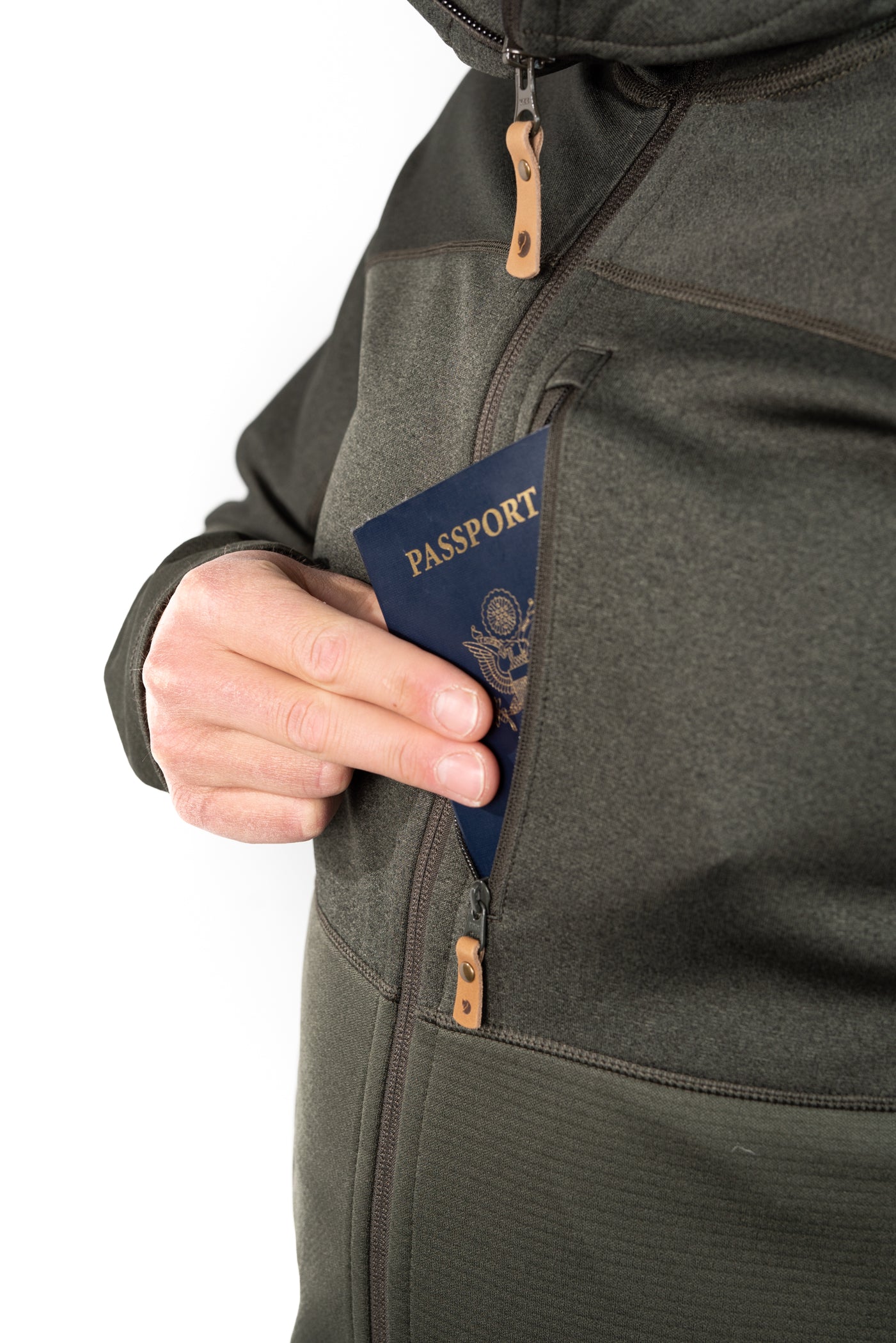 Dark green fleece jacket with multiple zippered pockets holding a passport