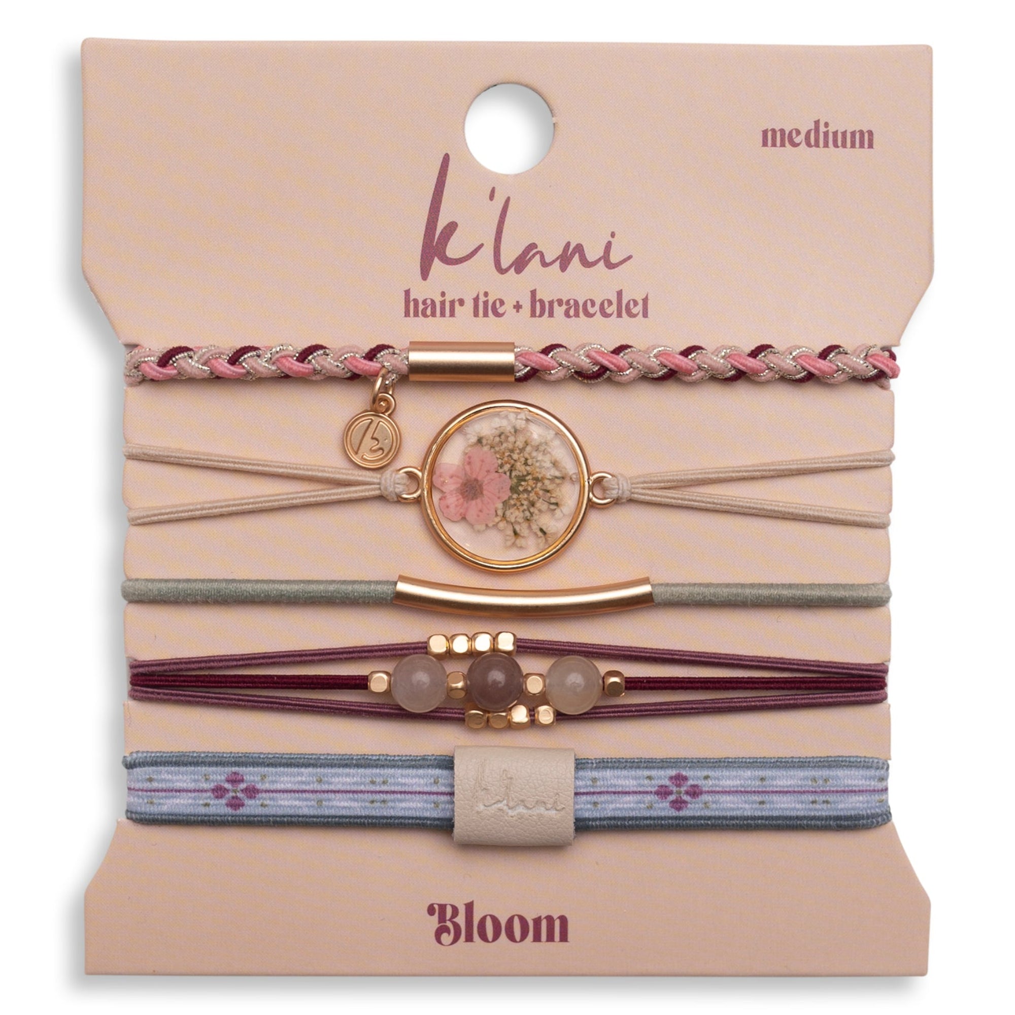Set of five hair tie bracelets with floral medallion, braided, beaded, and patterned elastic styles on packaging card