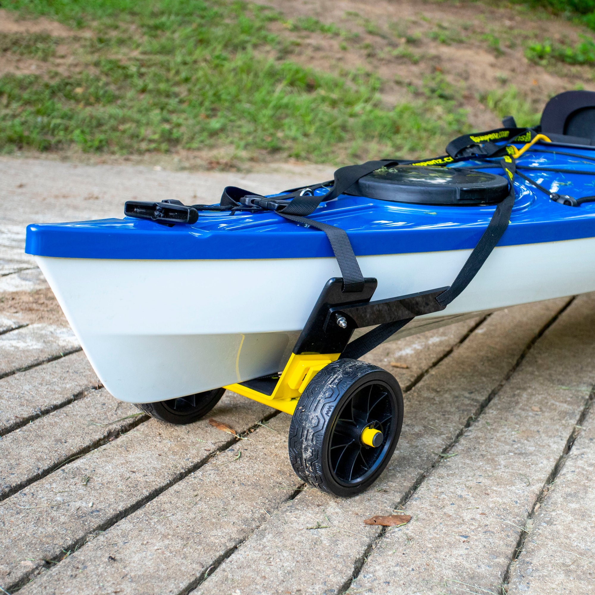 Kayak transport cart with two wheels supporting blue and white watercraft on paved surface