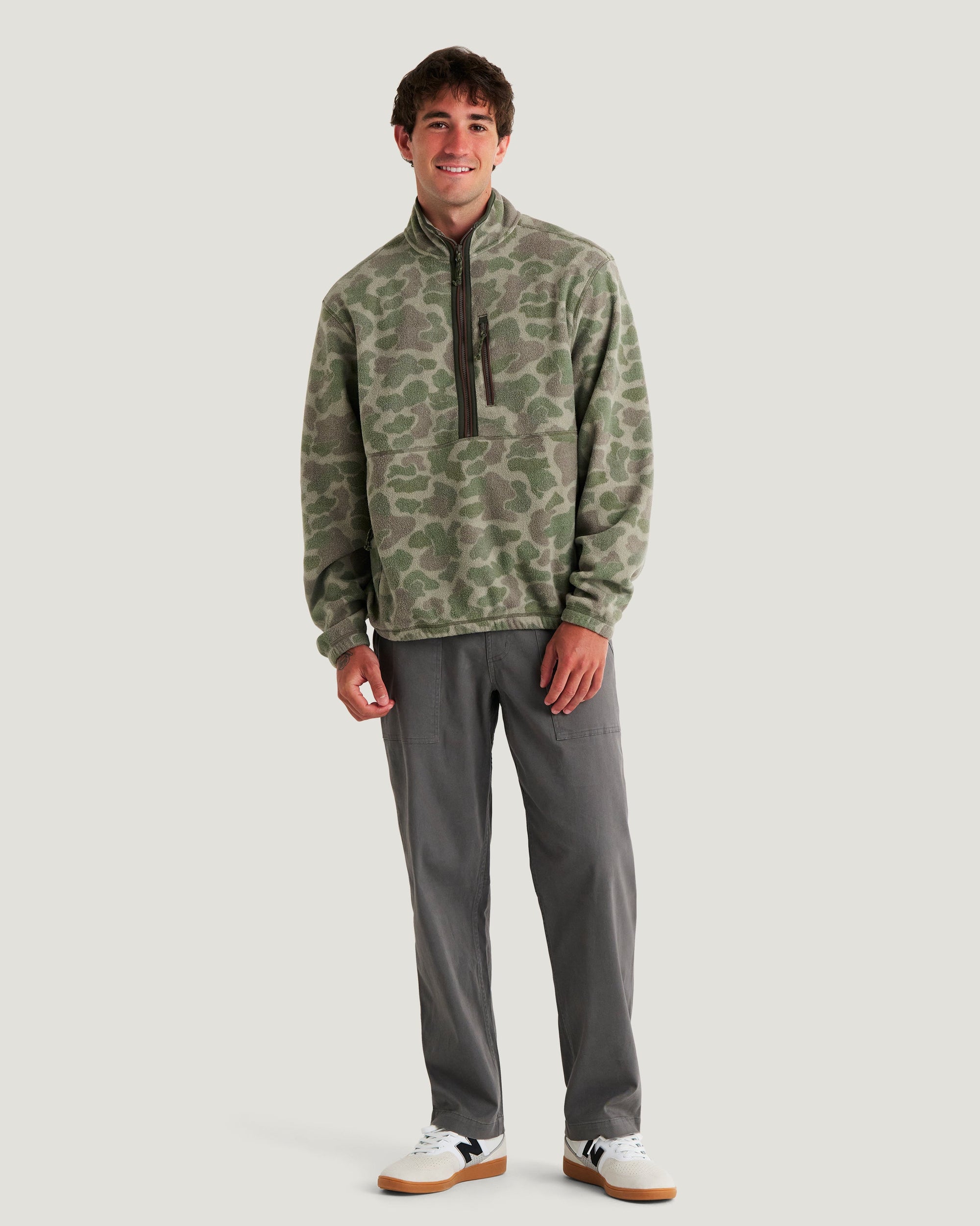Men's camo fleece half-zip pullover with chest zip pocket, front view on model