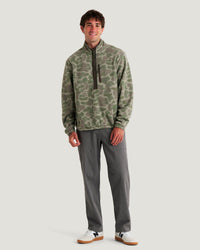 Men's camo fleece half-zip pullover with chest zip pocket, front view on model