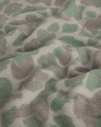 Close-up detail of fleece fabric with green and gray camouflage spot pattern
