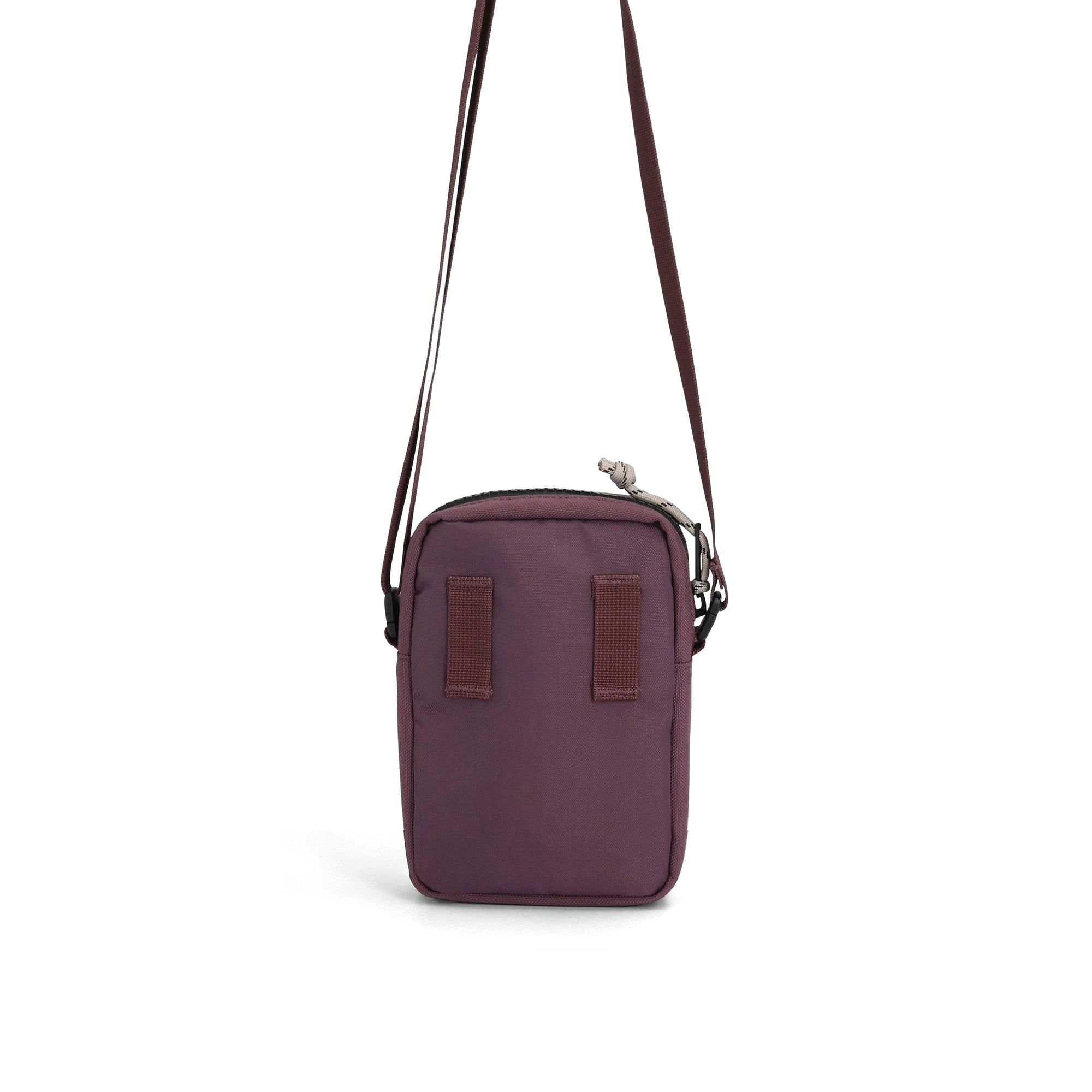 Small burgundy crossbody bag with adjustable strap and zippered compartment, studio shot