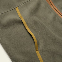 Close-up detail of fleece vest showing pocket opening with contrast woven strap and zipper trim