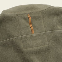 Close-up detail of olive green fleece vest showing quilted back panel and orange zipper pull