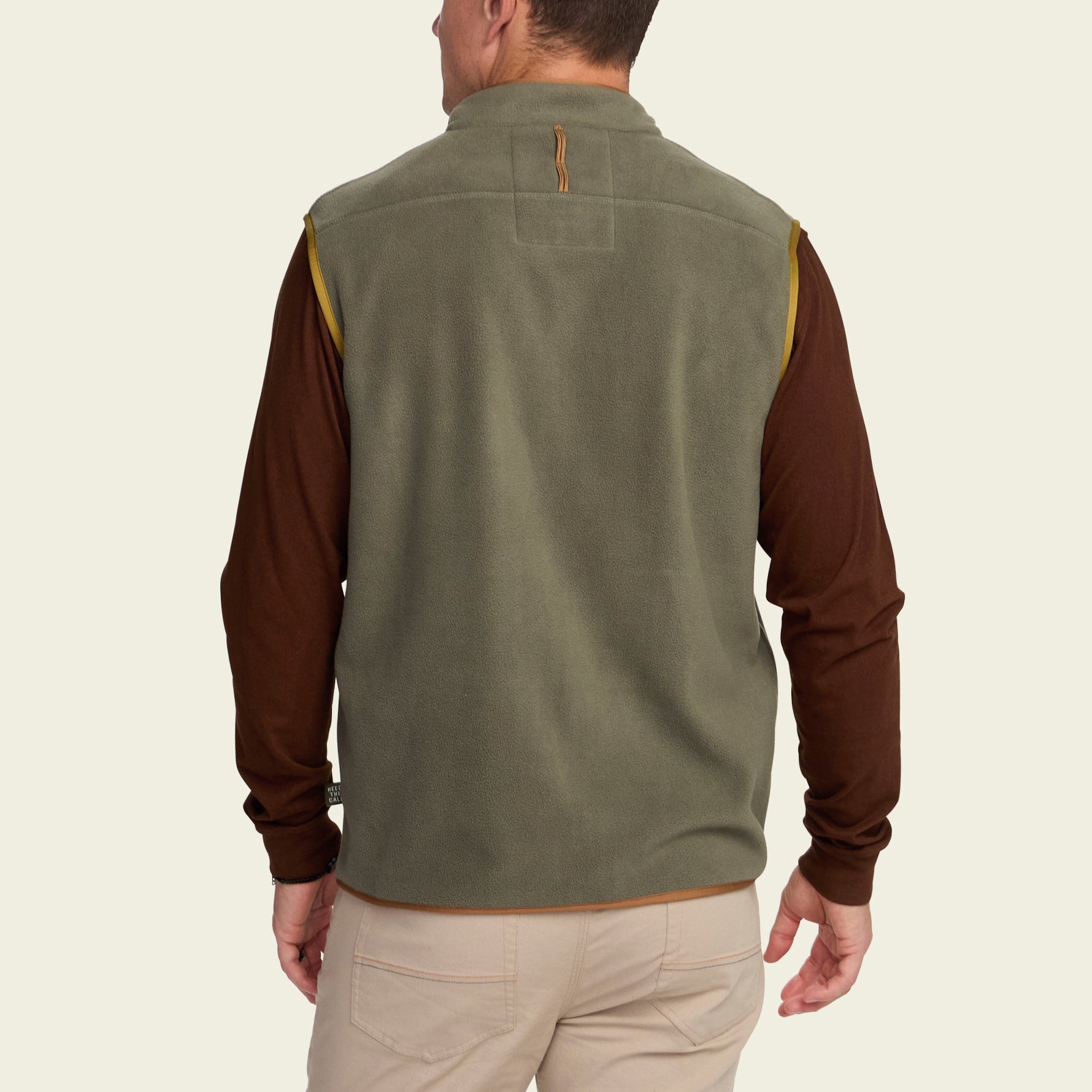 Men's fleece vest in olive green with gold trim, back view, worn over brown long-sleeve shirt