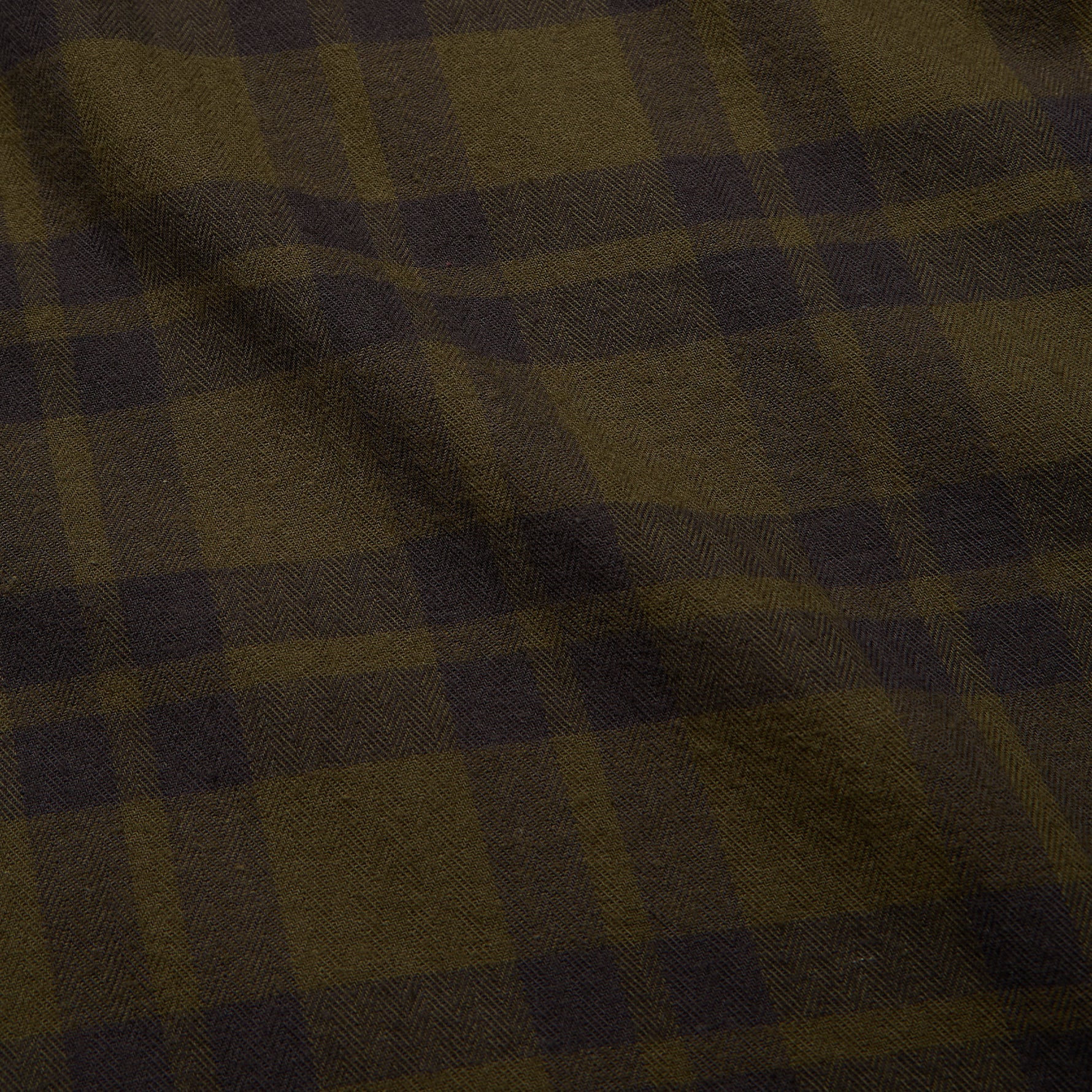 Close-up detail of lightweight flannel fabric showing olive and dark brown checkered plaid pattern