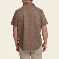 Men's short-sleeve floral print snap shirt, back view, worn with khaki pants