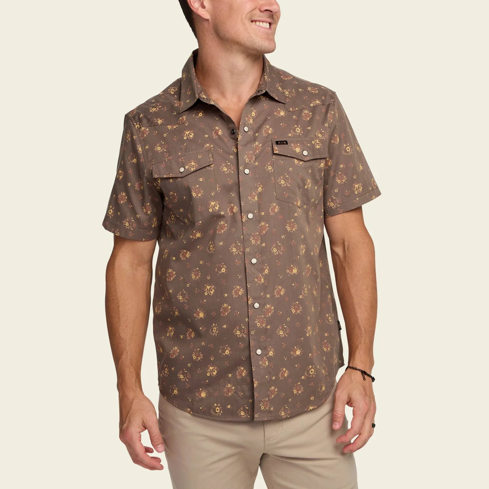 Men's short-sleeve snap-button shirt with floral print, dual chest pockets, front view on model